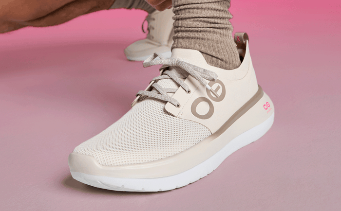 Men's Limited Edition 2025 OOmy Stride - Project Pink close up of model tying shoe in studio | lifestyle