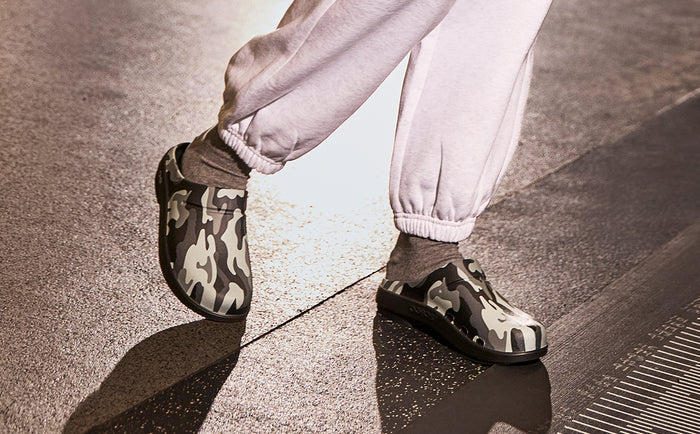 Men's OOcloog Luxe Clog - Night Camo model standing in indoor training facility | lifestyle