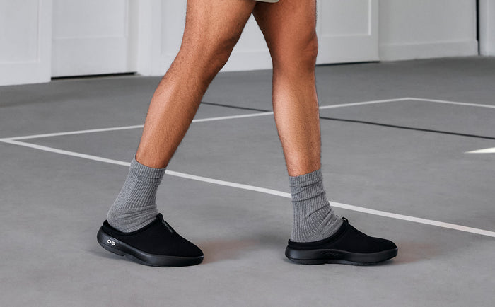 Men's OOcoozie Sport Mule - Black model walking in gym | lifestyle