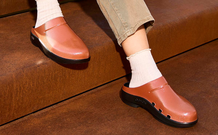 model sitting on steps wearing copper clog